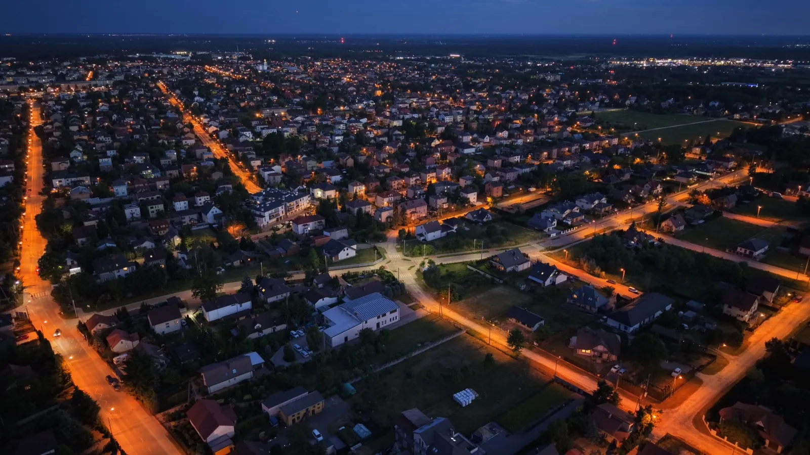 Oświetlone ulice i osiedla Mińska Mazowieckiego nocą, ujęcie z drona