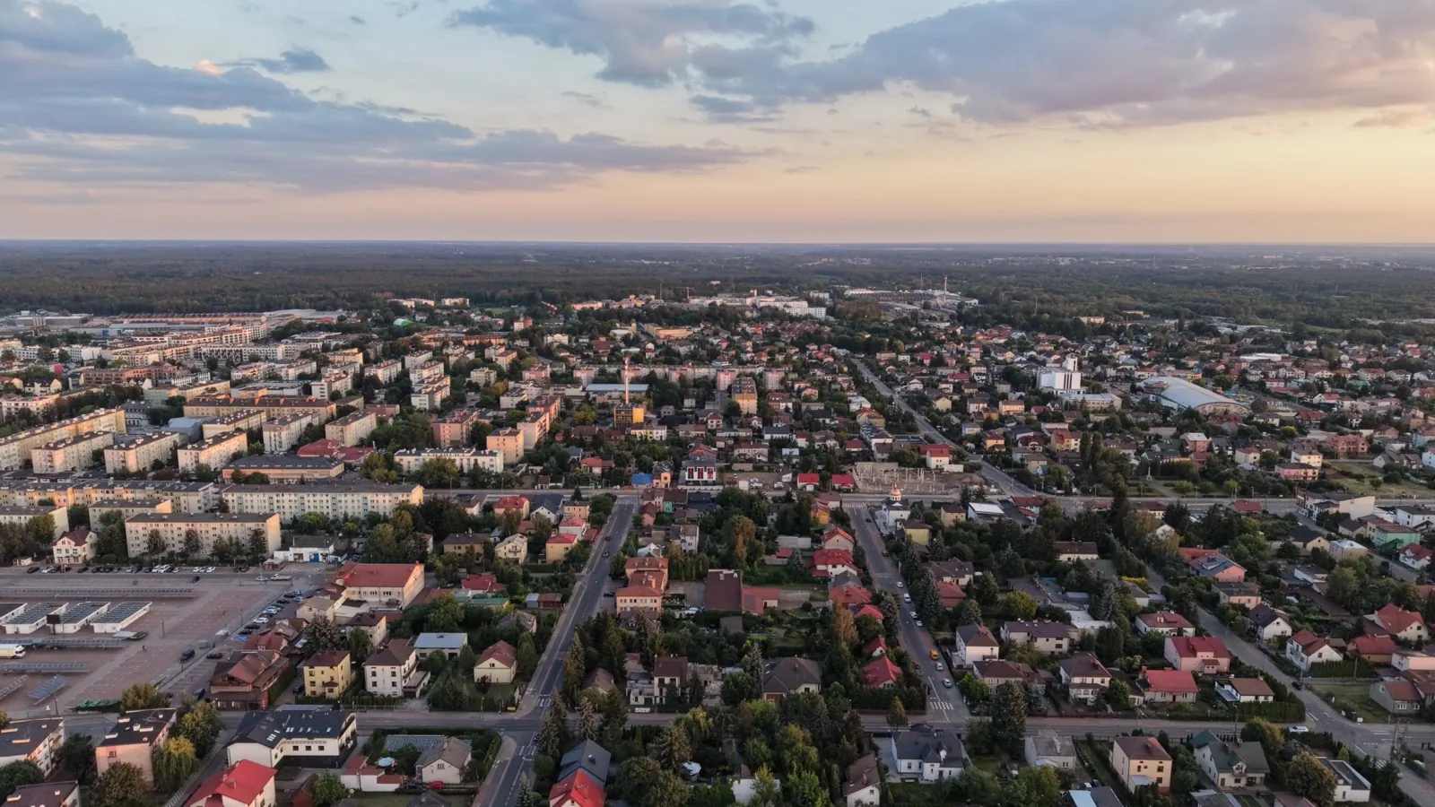 Panorama Mińska Mazowieckiego z lotu ptaka o zachodzie słońca, zabudowa i lasy na horyzoncie